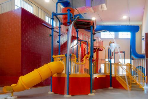 a playground with a yellow and red slide at Holiday Inn Omaha Downtown - Waterpark, an IHG Hotel in Omaha