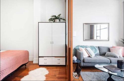 a living room with a couch and a bedroom at 1 Bedroom Apartment in CBD in Auckland