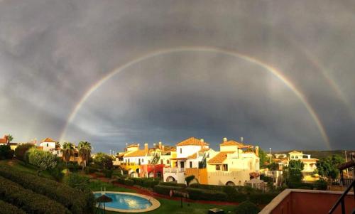 a rainbow in the sky over a group of houses at APARTAMENTO MANUELA PROXIMO a GOLF ISLA CANELA LINKS in Ayamonte