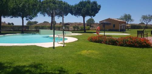 a yard with a swimming pool and a house at APARTAMENTO MANUELA PROXIMO a GOLF ISLA CANELA LINKS in Ayamonte