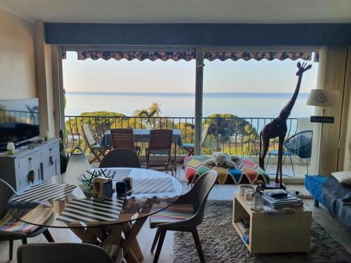 a living room with a table and a giraffe on a balcony at Appartement vue mer panoramique, plage 150M, terrasse, parking privé, clim in Cannes