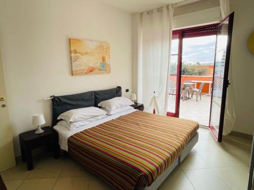 a bedroom with a large bed and a balcony at Regina Del Mare Holiday Apartments in Tirrenia