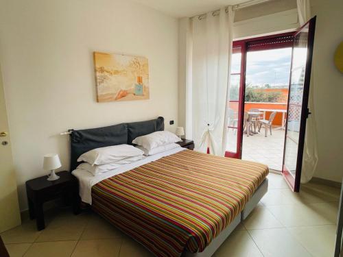 1 dormitorio con 1 cama grande y balcón en Regina Del Mare Holiday Apartments en Tirrenia