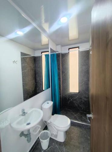ein Badezimmer mit einem weißen WC und einem Waschbecken in der Unterkunft Lujosa Mansión Privada estilo mediterráneo in Melgar