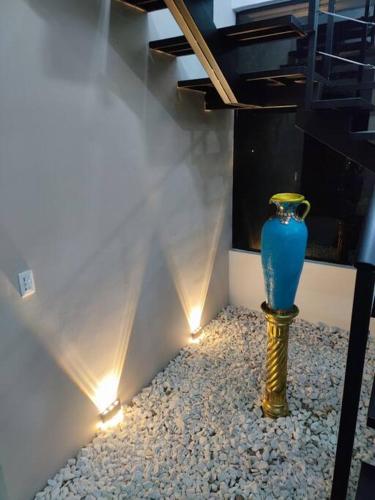 a blue vase sitting on a pile of rocks with lights at Lujosa Mansión Privada estilo mediterráneo in Melgar
