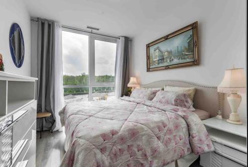 1 dormitorio con cama y ventana grande en Aquarius 2 Bedroom Condo Friday Harbour, en Innisfil