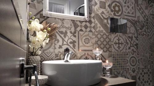 a bathroom with a sink and a mirror and flowers at Tesori di Girgenti in Agrigento