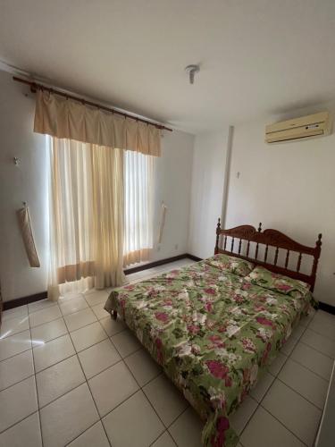 1 dormitorio con cama y ventana en Apartamento 5min da praia no Rio Vermelho, en Salvador