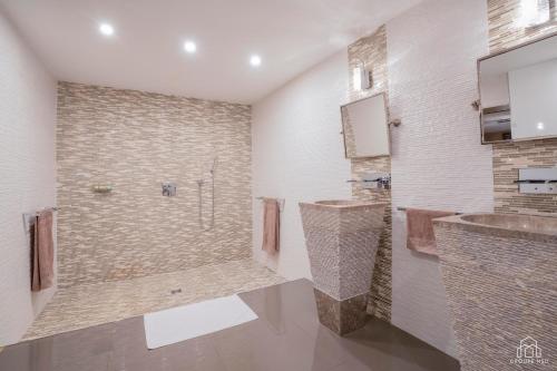 ein Badezimmer mit einer Dusche, 2 Waschbecken und einer Badewanne in der Unterkunft Château De La Feuilleraie Maison de Maître in Saint-Leu-la-Forêt