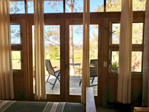 a bedroom with sliding glass doors to a deck at Casa Mayoral B&B Pet friendly in Valle de Guadalupe