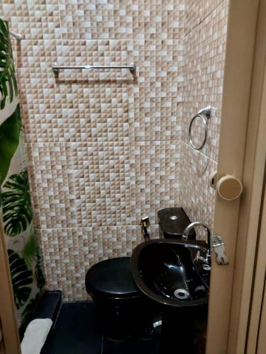 a bathroom with a black toilet and a sink at Perto do Pelourinho Quarto Arejado in Salvador