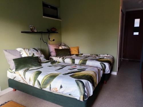two beds sitting next to each other in a bedroom at De Sprokkel in Milsbeek