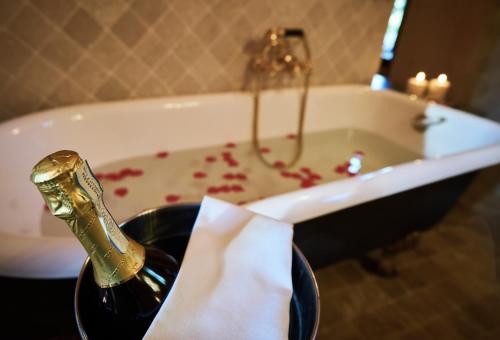 a bathroom with a bath tub with a gold faucet and red blood at Castello Di Tornano Wine Relais in Gaiole in Chianti