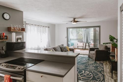 eine Küche und ein Wohnzimmer mit einem Sofa und einem Tisch in der Unterkunft Holualoa Gardens 101 in Kailua-Kona
