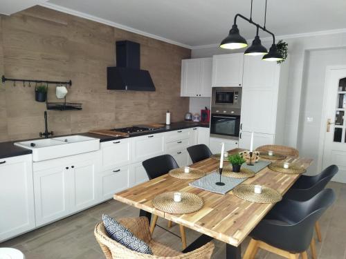 cocina con mesa de madera y algunas sillas en Piso grande con terraza en Finisterre