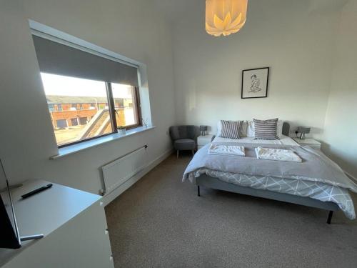 a bedroom with a bed and a large window at 2 Bedroom House with Garden Next to River Tees in Stockton-on-Tees