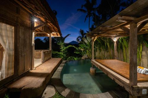 um pátio exterior com um banco e uma piscina de mergulho em Umah Capung Sebatu Villas em Tegalalang