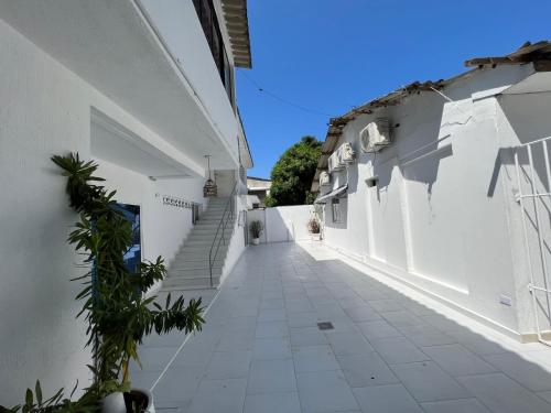 an empty alley with white walls and stairs at Private room MH102 close to old city in Cartagena de Indias