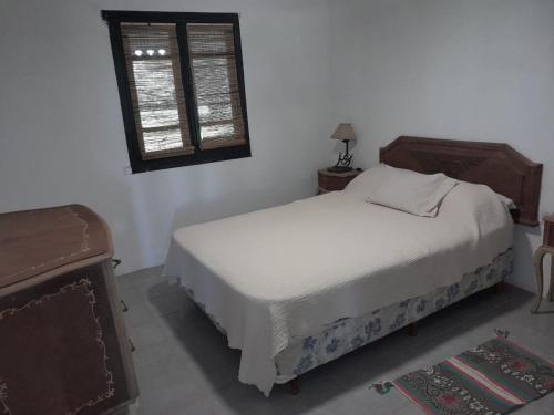 een slaapkamer met een wit bed en een raam bij La Angelita in San Andrés de Giles
