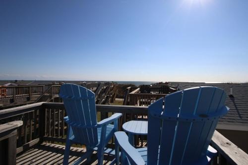 two blue chairs and a table on a balcony at NC 12 56821-15 Condo in Hatteras