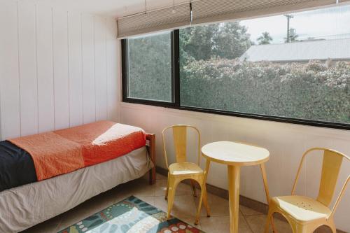 a bedroom with a bed and two chairs and a table at Holualoa Garden 103 in Kailua-Kona