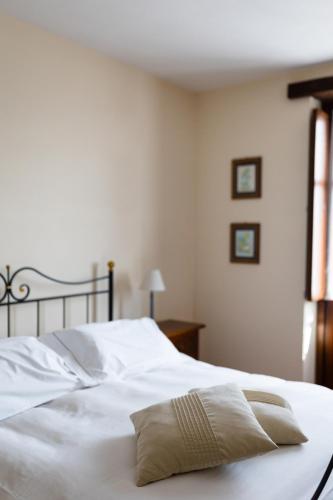 a bed with white sheets and a pillow on it at Radice Verde in Cissone