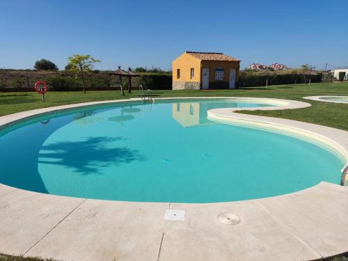 a large swimming pool with a house in the background at APARTAMENTO MANUELA PROXIMO a GOLF ISLA CANELA LINKS in Ayamonte
