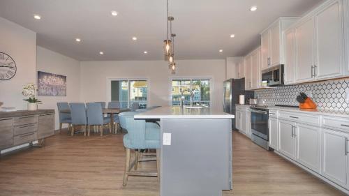 a kitchen with white cabinets and blue chairs in it at 802 Dye Townhouse home in North Myrtle Beach
