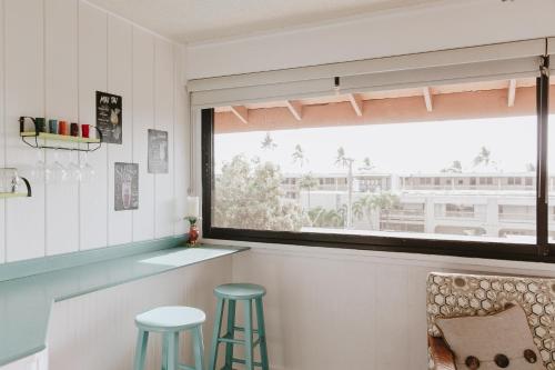 uma cozinha com dois bancos e uma janela em Holualoa Garden 303 em Kailua-Kona