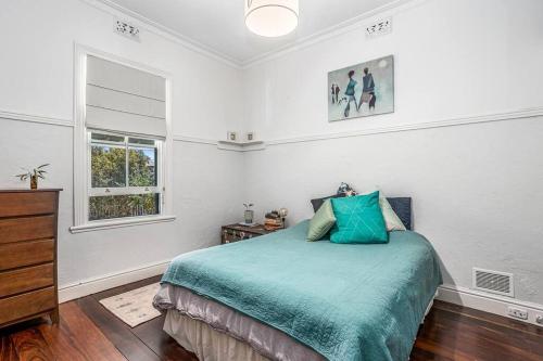Un dormitorio con una cama y una cómoda y una ventana. en Saltbush Cottage in fabulous South Fremantle, en South Fremantle