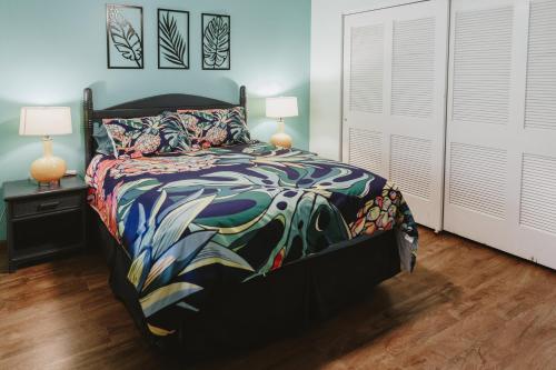 a bedroom with a bed with a colorful comforter at Holualoa Garden 303 in Kailua-Kona