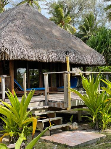 a hut with a bench and a thatch roof at Fare Ahuna in Bora Bora