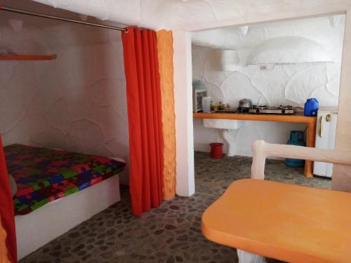 Habitación pequeña con cama y cocina en Flintstone Mini-Cave, en Poctoy