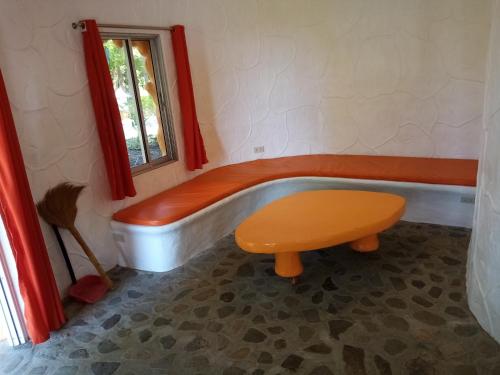 Cette chambre dispose d'une baignoire, d'une table et d'une fenêtre. dans l'établissement Flintstone Mini-Cave, à Poctoy