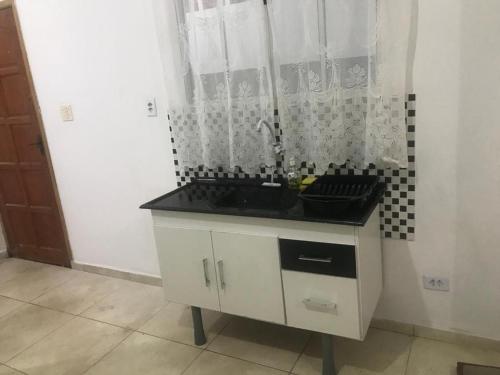 een keuken met een wastafel en een zwart aanrecht bij Cantinho da Nega - AP INTEIRO - IMPOSTOS E TAXAS INCLUSOS in São Vicente