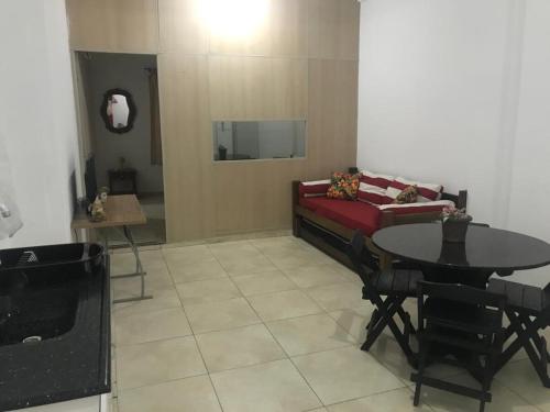 een woonkamer met een rode bank en een tafel bij Cantinho da Nega - AP INTEIRO - IMPOSTOS E TAXAS INCLUSOS in São Vicente