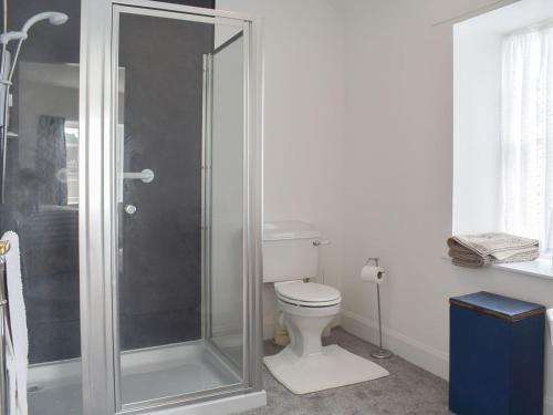 a bathroom with a toilet and a glass shower at Old Manse Annex in Town Yetholm