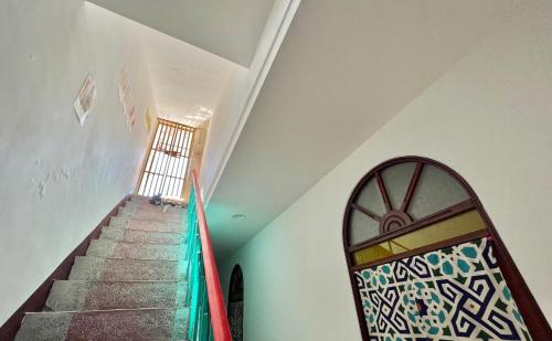 a staircase in a house with a window and a stair case at Sun Moment 鬆貓們民宿 in Toucheng