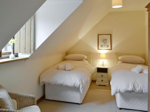 Newland的住宿－Honey Cottage，阁楼卧室设有两张床和楼梯。
