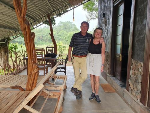a man and a woman standing on a porch at Ceylon Resort in Wilpattu