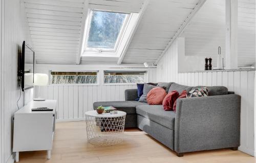 a living room with a gray couch and a table at Awesome Home In Glesborg With Sauna in Glesborg