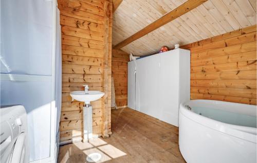 a bathroom with a sink and a tub and a toilet at Awesome Home In Glesborg With Sauna in Glesborg
