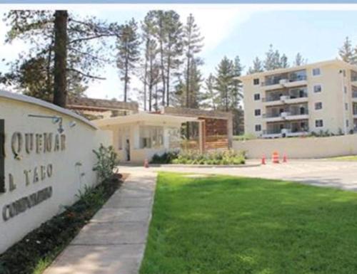 a building with a grass yard and a building at ¡¡Disfruta En Parquemar El Tabo!! in El Tabo