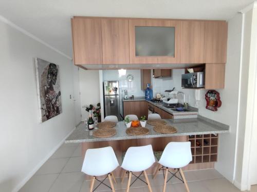 a kitchen with white stools and a counter top at ¡¡Disfruta En Parquemar El Tabo!! in El Tabo