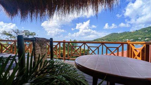 a table and chair on a balcony with a view of the ocean at Sunset Lane in Laborie