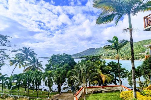 a view of the water from a resort with palm trees at Sunset Lane in Laborie