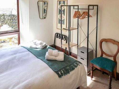 1 dormitorio con 1 cama con toallas en Yew Tree Farm, en High Newton