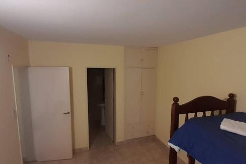 1 dormitorio con 1 cama y puerta al baño en Comodo departamento en Cordoba en Córdoba