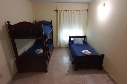 1 dormitorio con 2 literas y 1 silla en Comodo departamento en Cordoba en Córdoba