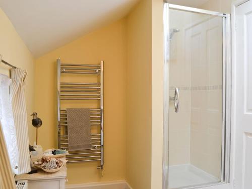 ein Bad mit einer Dusche und einer Glastür in der Unterkunft Broadoak Barn in Ellesmere